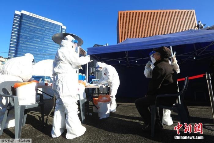 資料圖：韓國(guó)首爾，醫(yī)務(wù)人員對(duì)市民進(jìn)行新冠病毒檢測(cè)。