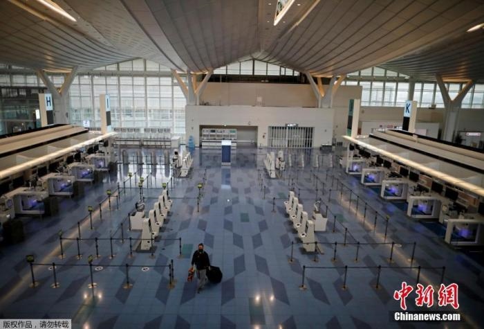 資料圖：日本東京，東京國際機(jī)場，一名乘客在國際航班航站樓的登機(jī)區(qū)。