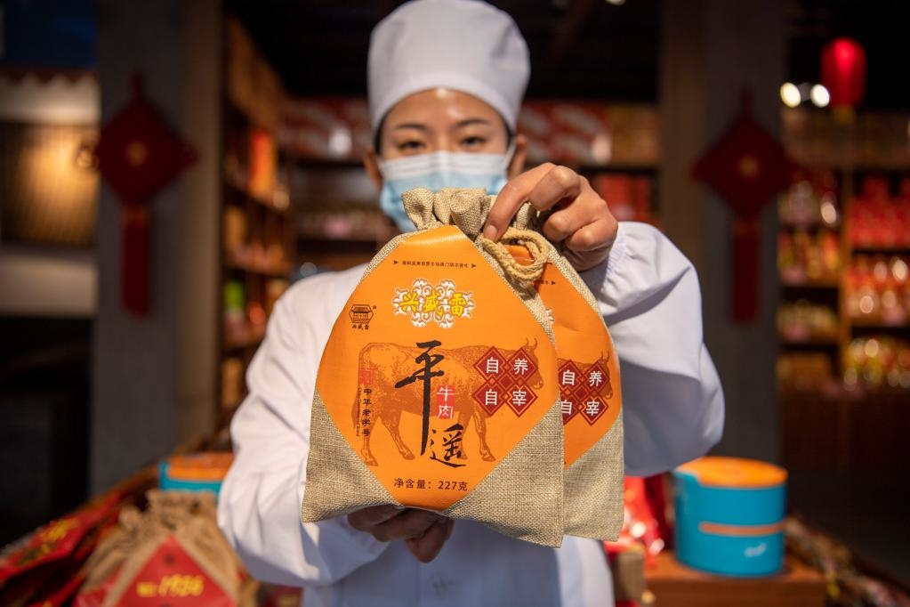 1月27日，在平遙古城南大街的一家平遙牛肉店內(nèi)，工作人員展示一款牛肉產(chǎn)品。新華社記者 楊晨光 攝