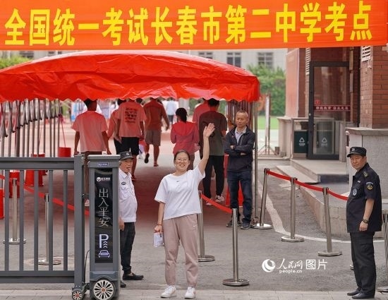 6月7日，在長春市第二中學(xué)考點，一名考生信心滿滿進入考場，并與家長揮手致意。人民網(wǎng)記者 李洋攝