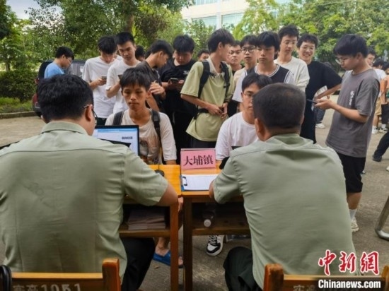 專武干部在發(fā)放兵役登記證。韋碩 攝