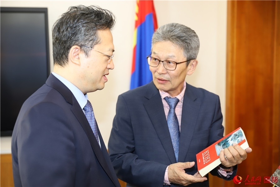 其米德策耶（右一）向李峙介紹翻譯成果。人民網(wǎng)記者 霍文攝