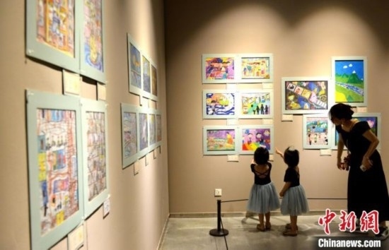 圖為家長(zhǎng)帶著孩子參觀展覽。呂明 攝