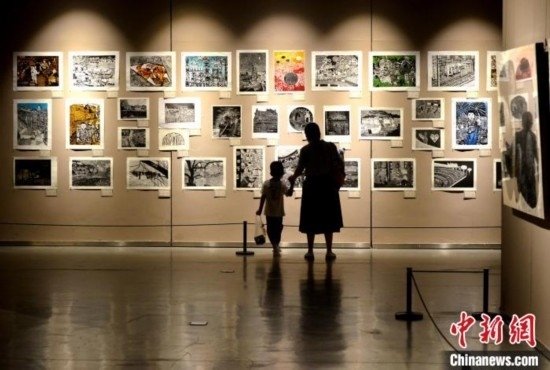 圖為家長(zhǎng)帶著孩子參觀展覽。呂明 攝