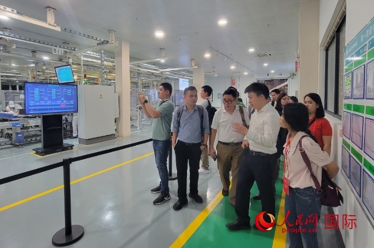 廣汽埃安工作人員向外媒記者進行介紹。人民網(wǎng) 寧玉瑛攝