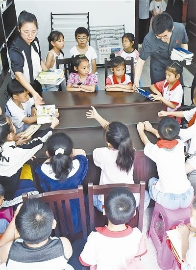  圖④：法院干警為留守兒童發(fā)放暑假讀物。