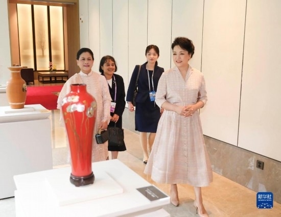 7月27日下午，國家主席習(xí)近平夫人彭麗媛在四川成都會見陪同印度尼西亞總統(tǒng)佐科來華出席第31屆世界大學(xué)生夏季運動會開幕式并訪華的總統(tǒng)夫人伊莉亞娜。這是彭麗媛和伊莉亞娜欣賞成都特色非遺工藝品。新華社記者 丁林 攝