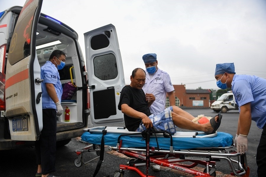 8月1日，在北京市門頭溝區(qū)妙峰山鎮(zhèn)妙峰山民族學(xué)校臨時(shí)安置點(diǎn)，北京急救中心工作人員在轉(zhuǎn)運(yùn)一名受傷村民。新華社記者 鞠煥宗 攝