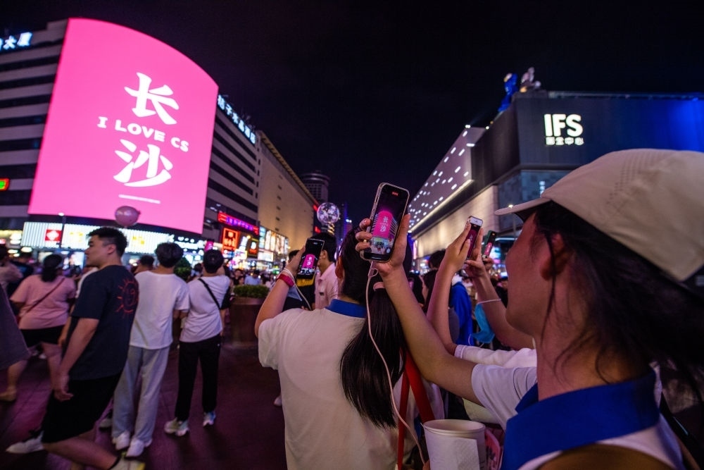  游客在長(zhǎng)沙市天心區(qū)黃興路步行街打卡、拍照（6月7日攝）。新華社記者 陳思汗 攝