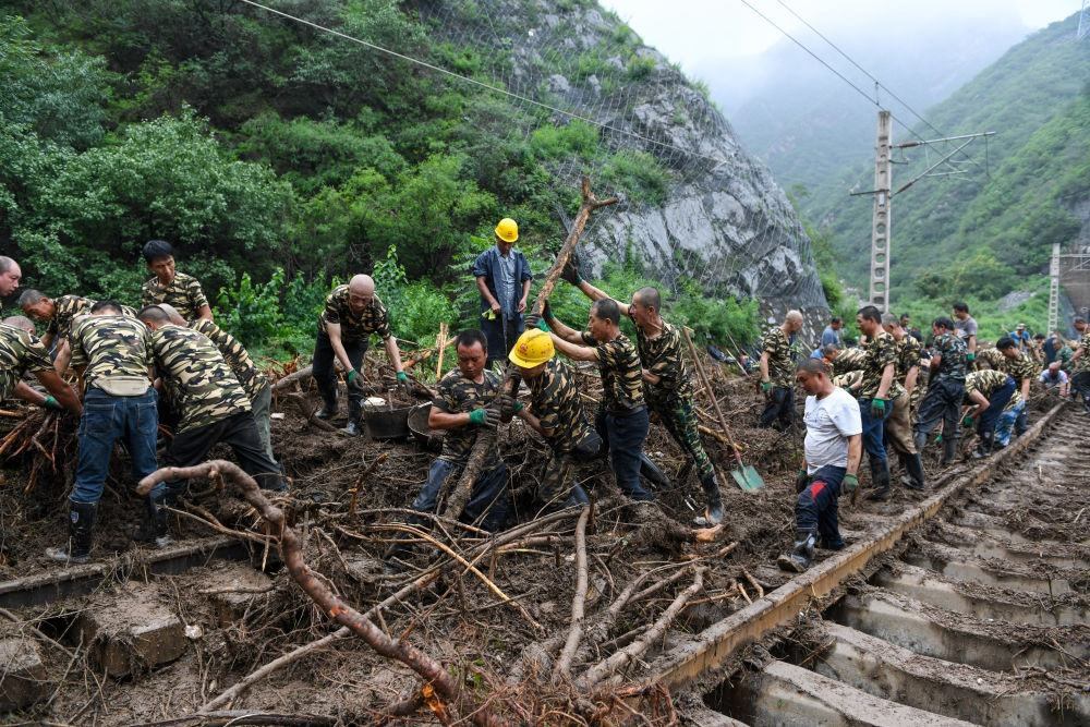 8月1日，在北京市門頭溝區(qū)水峪嘴村附近一段被阻斷的鐵路線上，中鐵六局工作人員在清理軌道上的雜物，全力恢復交通。新華社記者 鞠煥宗 攝