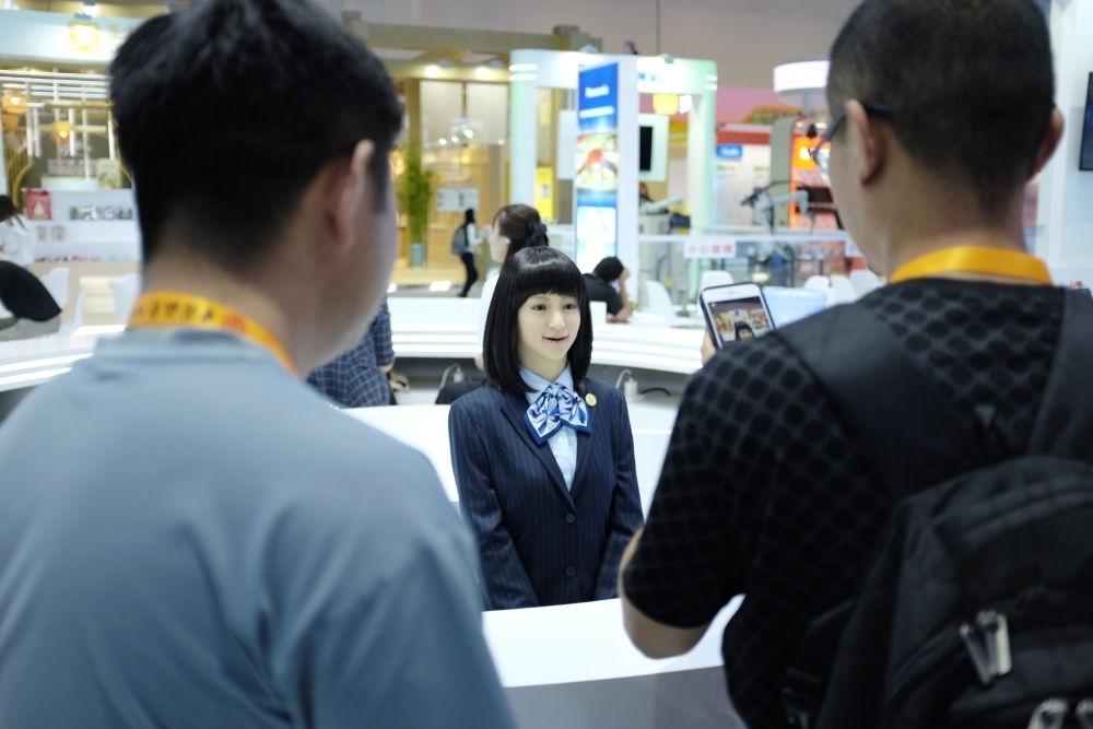 9月1日，媒體記者在國家會議中心與服務(wù)機(jī)器人互動。新華社記者 劉夢琪 攝