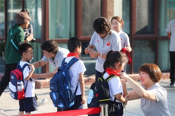 8月30日，雄安史家胡同小學(xué)學(xué)生體驗學(xué)校生活。老師為學(xué)生佩戴?；铡? /></p> <p style=