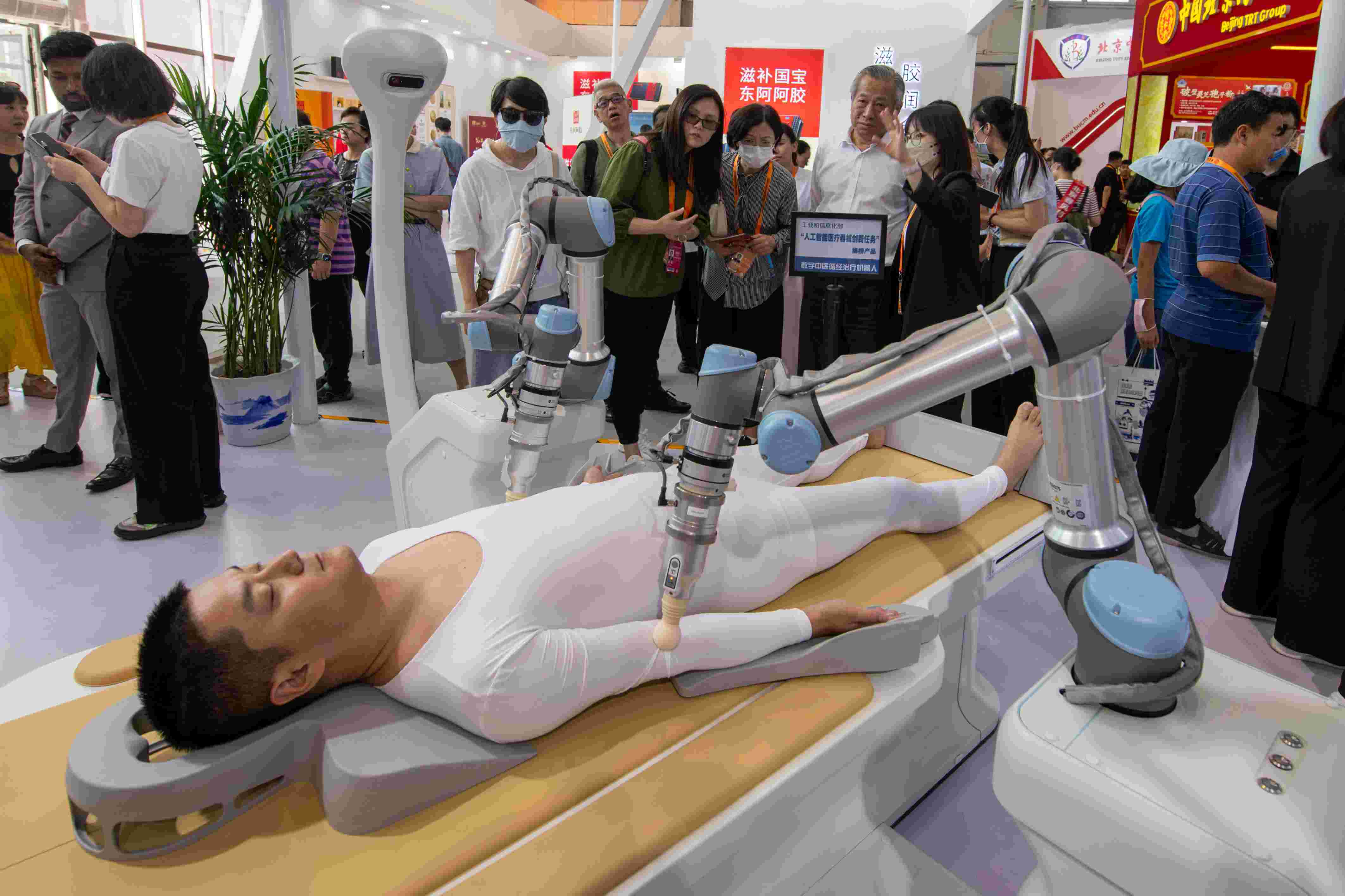 在位于首鋼園的健康衛(wèi)生服務(wù)展區(qū)，觀眾正在參觀數(shù)字中醫(yī)循經(jīng)治療機器人。人民網(wǎng)記者 翁奇羽攝