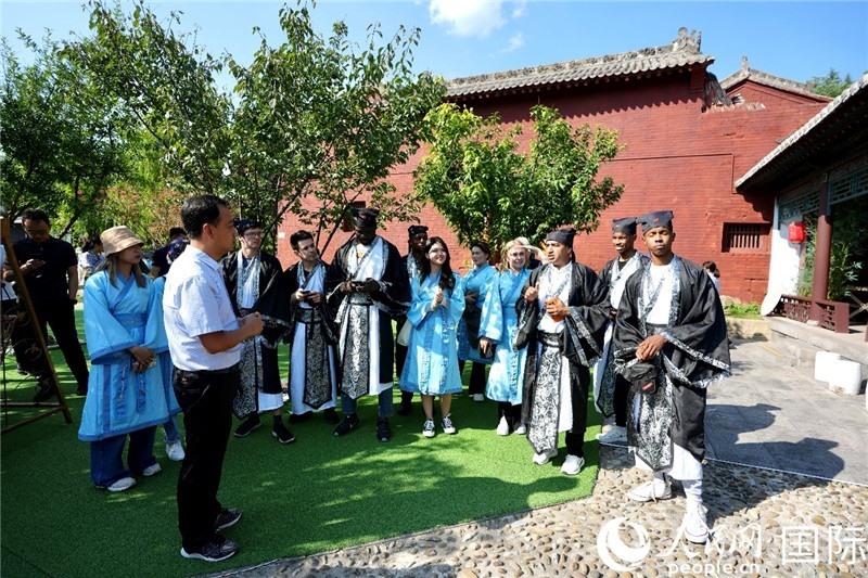 圖為選手們聽導(dǎo)游講解。人民網(wǎng) 盧鵬宇攝