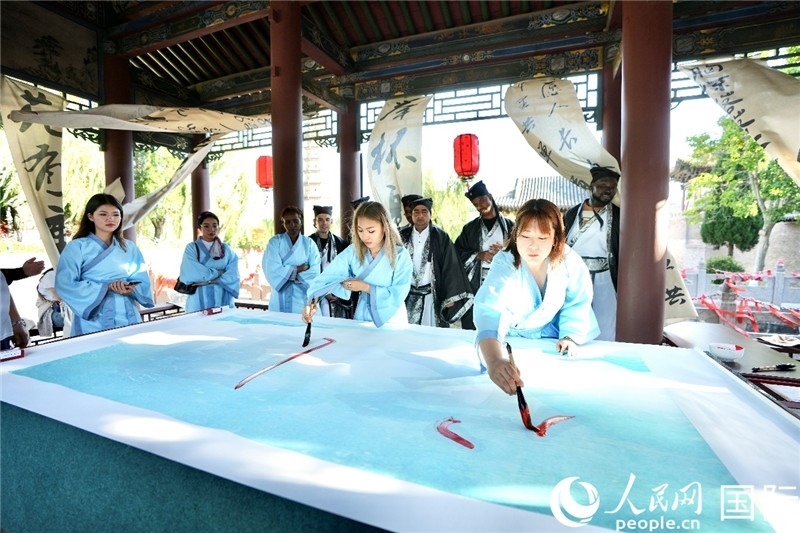 選手們提筆書寫“家園”二字。人民網(wǎng) 盧鵬宇攝