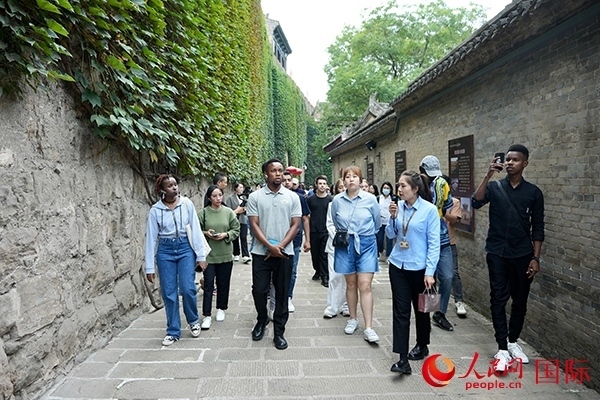 選手們認真聆聽導(dǎo)游講解。人民網(wǎng) 盧鵬宇攝