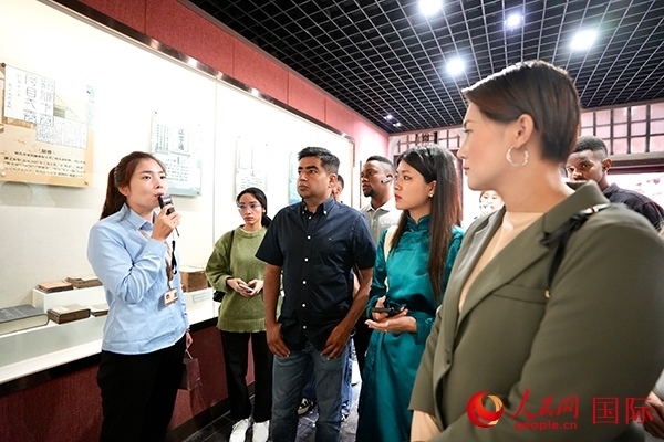 選手們認真聆聽導(dǎo)游講解。人民網(wǎng) 盧鵬宇攝