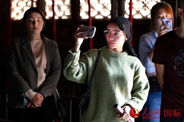 選手顏青（蘇丹）用手機記錄所見所感。人民網(wǎng) 盧鵬宇攝