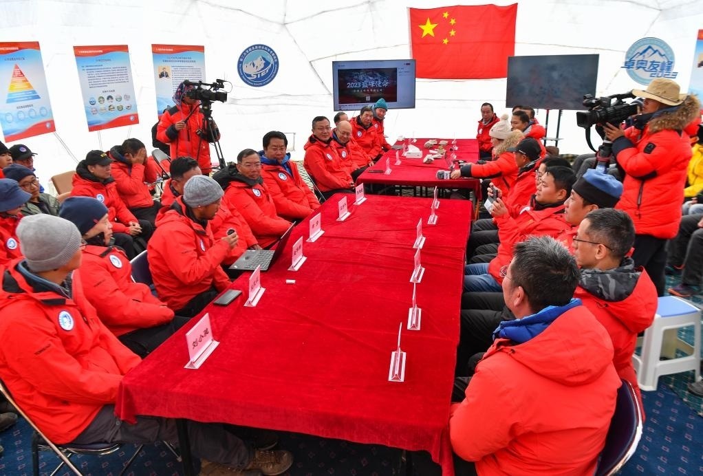 海拔4950米的卓奧友峰科考大本營，科考隊員趙華標（手拿麥克風看電腦者）在宣讀剛剛接收到的頂峰氣象觀測數(shù)據(jù)，這標志著峰頂自動氣象站架設成功，成功傳回觀測數(shù)據(jù)（10月1日攝）。新華社記者晉美多吉 攝