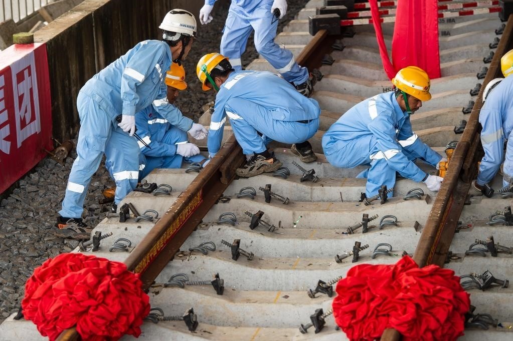 3月31日，在印度尼西亞雅加達(dá)雅萬高鐵哈利姆車站，工人鋪設(shè)雅萬高鐵全線最后一根鋼軌。