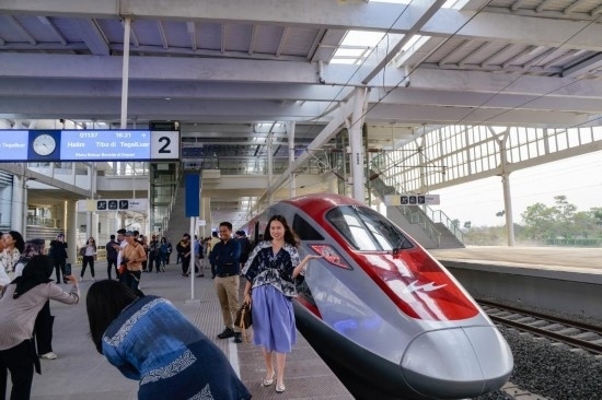  10月17日，在印度尼西亞萬隆德卡魯爾站，乘客在站臺上和雅萬高鐵高速動車組列車合影。新華社記者 徐欽 攝