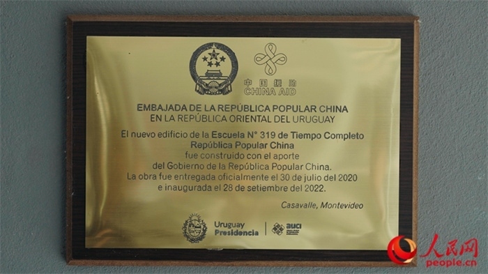 小學(xué)墻上懸掛的中國援助標識。人民網(wǎng)記者 張若涵攝