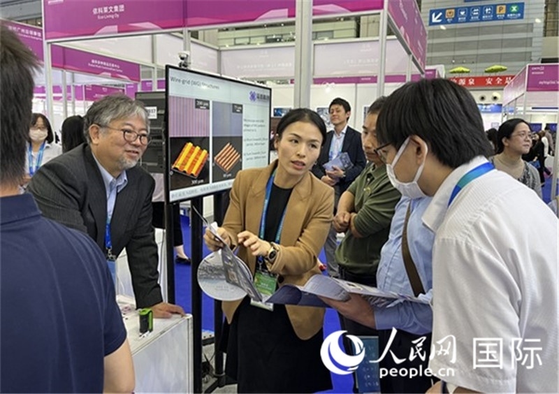 工作人員向參觀者介紹超級(jí)噴墨技術(shù)。（人民網(wǎng)記者 陳思攝）