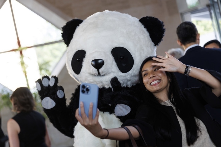 2022年8月24日，在美國(guó)華盛頓中國(guó)駐美國(guó)大使館，來(lái)賓與大熊貓玩偶合影。