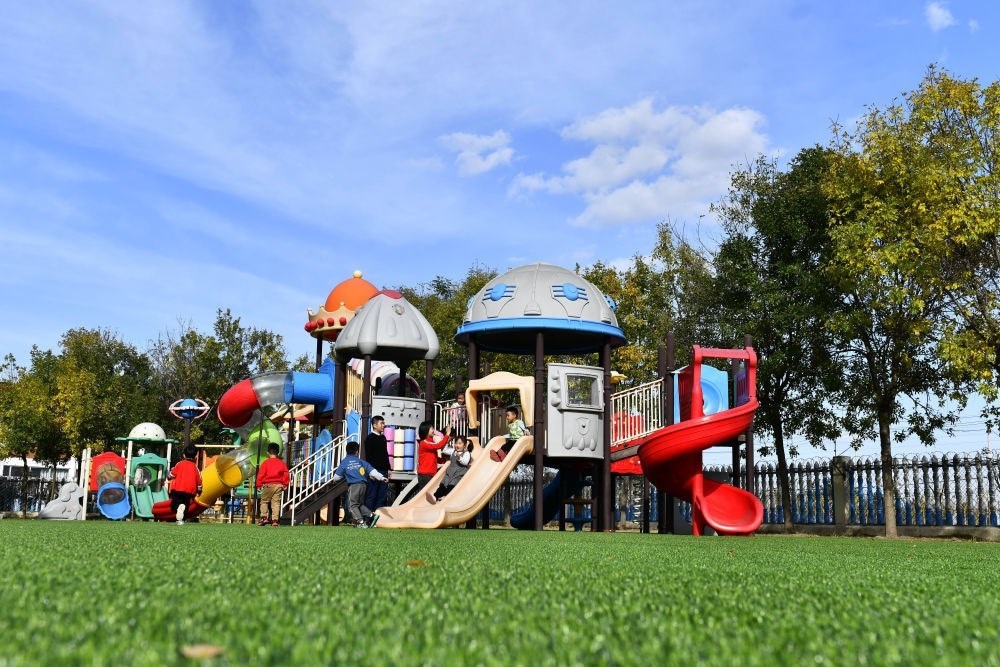 在山東省東營(yíng)市墾利區(qū)楊廟社區(qū)幼兒園，孩子們?cè)诶蠋煹膸ьI(lǐng)下進(jìn)行戶(hù)外活動(dòng)（2021年10月19日攝）。新華社記者 郭緒雷 攝