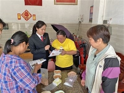  圖⑤：龍圩區(qū)法院法官到群眾家中開展法治宣傳。資料圖片