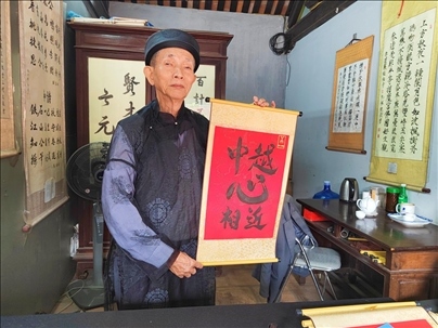 越南首都河內(nèi)文廟內(nèi)，阮明珠展示“中越心相近”書法作品。