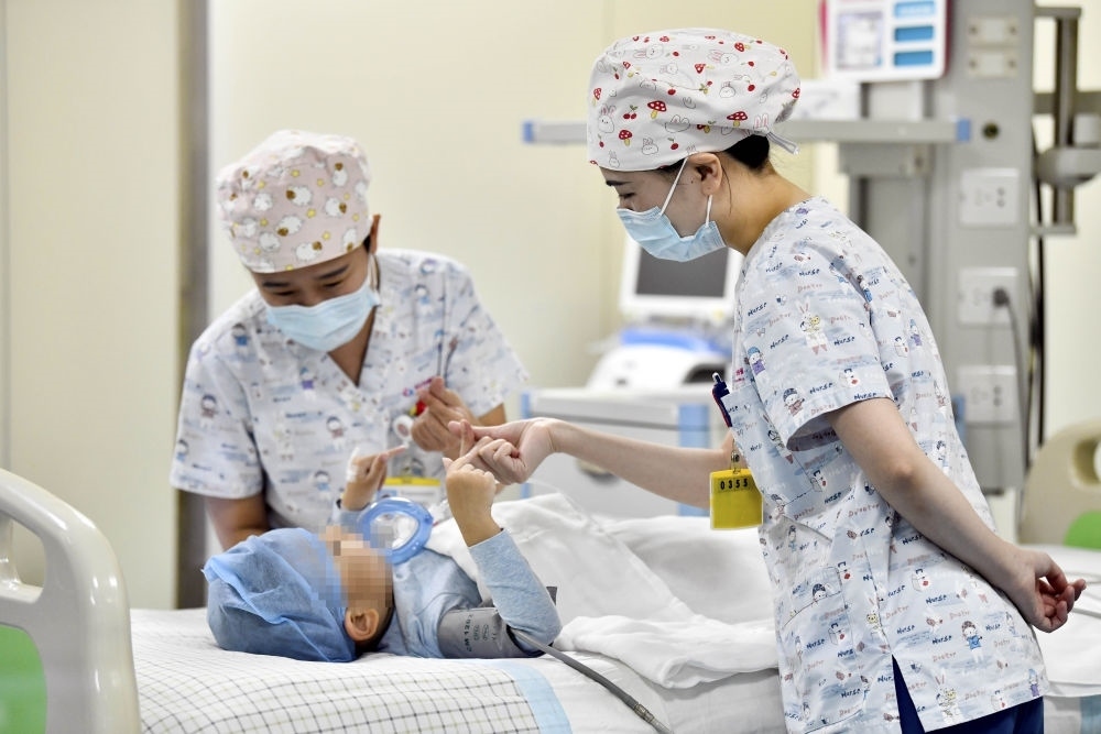 在山東省棗莊市婦幼保健院兒童ICU病房，醫(yī)護(hù)人員為完成靶向治療藥物諾西那生鈉的4歲脊髓性肌萎縮癥患兒加油鼓勁（2022年1月1日攝）。諾西那生鈉注射液是我國(guó)首個(gè)獲批治療脊髓性肌萎縮癥的進(jìn)口藥物，2019年進(jìn)入中國(guó)市場(chǎng)時(shí)，每針價(jià)格近70萬元。在2021年國(guó)家醫(yī)保目錄藥品談判中，以3.3萬元每針的價(jià)格進(jìn)入新版醫(yī)保藥品目錄。新華社記者 郭緒雷 攝