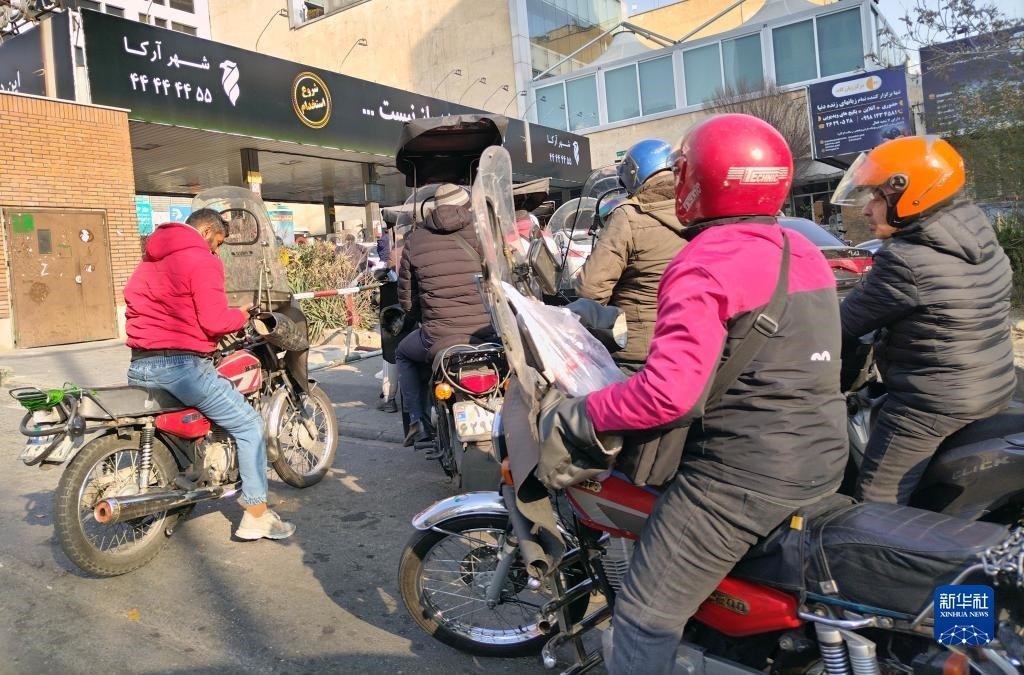 12月18日，摩托車在伊朗首都德黑蘭的一家加油站外等待加油。新華社記者 沙達(dá)提 攝