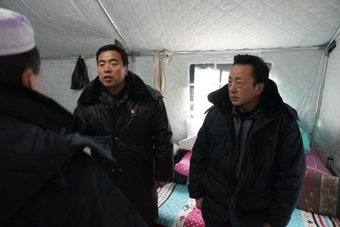 2023年12月22日，積石山縣大河家鎮(zhèn)大河村黨支部書記馬成忠（右二）在帳篷里和受災(zāi)群眾交流。新華社記者 陳斌 攝