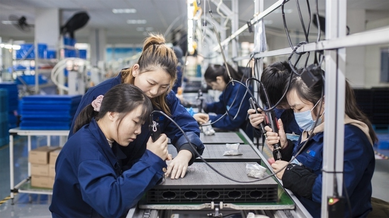 在新亞勝光電的產(chǎn)品線上，工人正進行產(chǎn)品組建和安裝布線。受訪者供圖