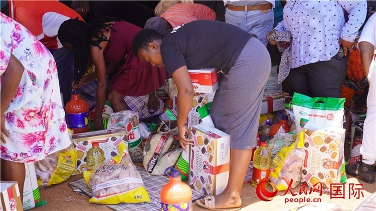 當(dāng)?shù)厣鐓^(qū)家庭領(lǐng)取物資。人民網(wǎng) 張茜攝