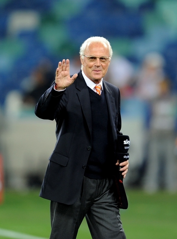 這是2010年7月7日，在南非德班舉行的2010年足球世界杯德國(guó)隊(duì)對(duì)陣西班牙隊(duì)的半決賽前，貝肯鮑爾接受電視臺(tái)采訪時(shí)和友人打招呼。新華社記者 王毓國(guó) 攝