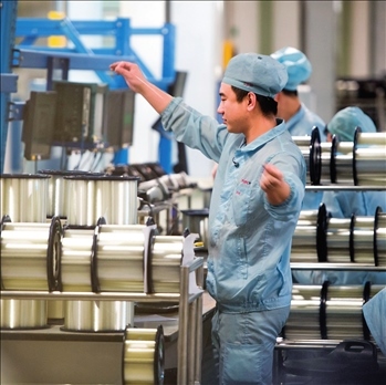 在位于武漢的長飛光纖光纜股份有限公司光纖生產(chǎn)車間內(nèi)，工作人員對光纖進行檢測（資料圖片）。肖藝九攝/本刊