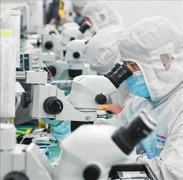 在位于武漢中國光谷的光電器件研發(fā)制造商——武漢光迅科技股份有限公司生產(chǎn)車間內(nèi)，技術(shù)人員在光模塊生產(chǎn)線作業(yè)（2023年4月11日攝）。程敏攝/本刊