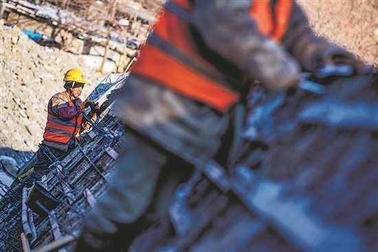 1月3日，房山區(qū)，工人正在雙泉河修筑堤壩。