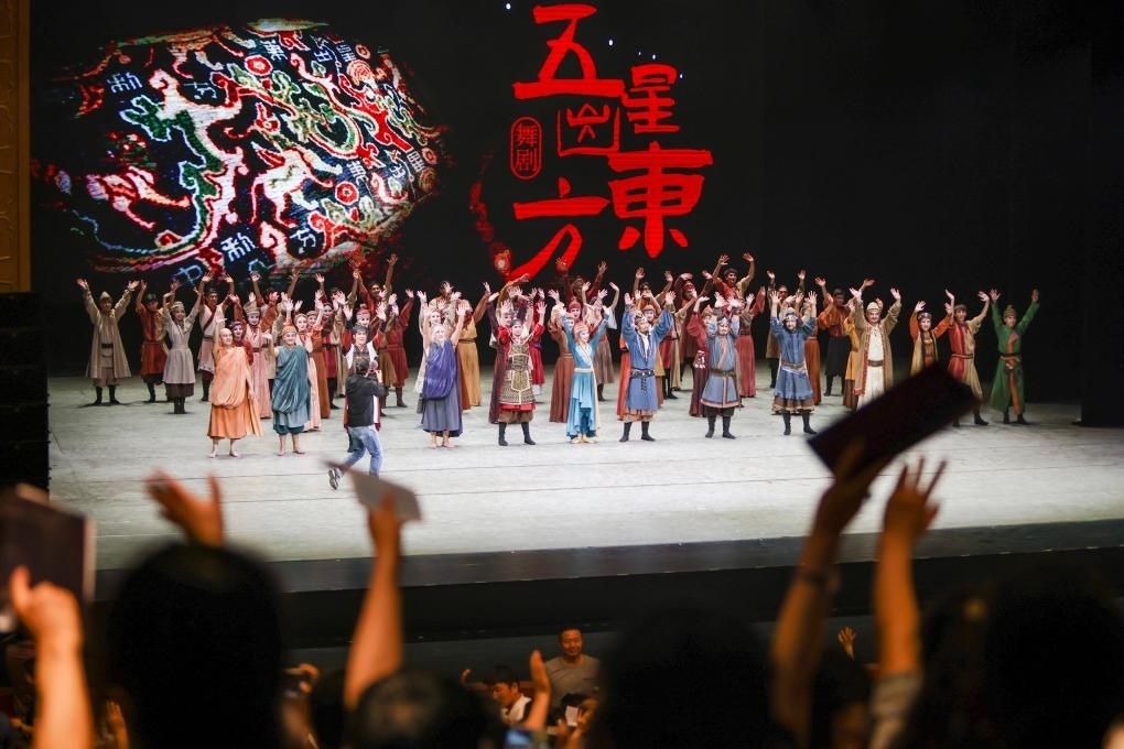 2023年7月31日，新疆和田地區(qū)新玉歌舞團(tuán)在烏魯木齊京劇院演出舞劇《五星出東方》后和觀眾互相揮手致意。這場演出是第六屆中國新疆國際民族舞蹈節(jié)的參演劇目之一，曾榮獲國家“文華獎(jiǎng)”等。新華社記者 郝昭 攝