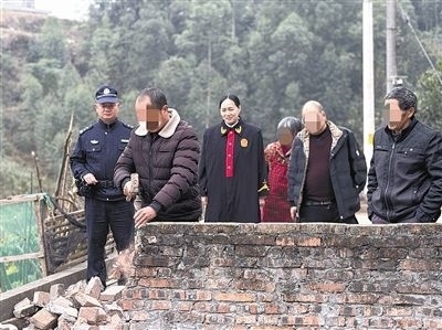  圖③：庭審結束后，在法官的見證下，陳某在院壩邊重新開鑿一條通道。