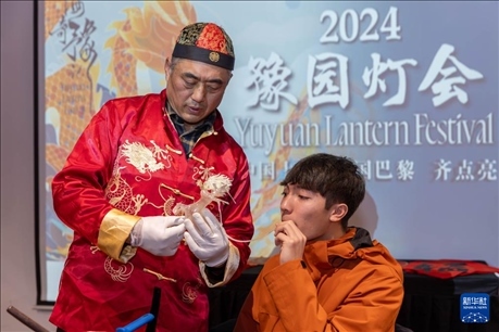 1月28日，在上海豫園舉行的民俗活動上，美國馬斯卡廷中學(xué)學(xué)生在非遺傳承人的指導(dǎo)下吹糖偶。 新華社記者 王翔 攝