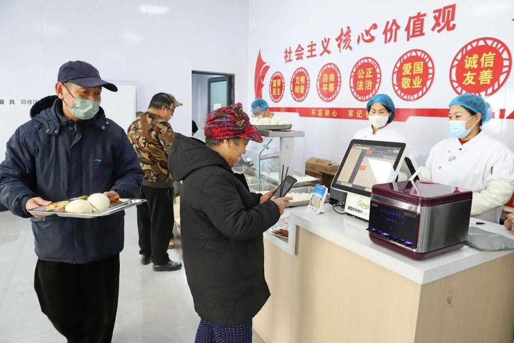 △2024年2月1日，市民在河北涿州市雙塔街道永濟(jì)秀園小區(qū)便民食堂內(nèi)購買午餐。