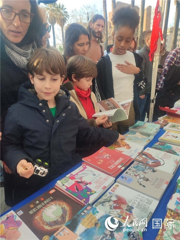 印刷精美的中國(guó)傳統(tǒng)文化叢書吸引了小游客的注意。人民網(wǎng)記者鄭彬攝