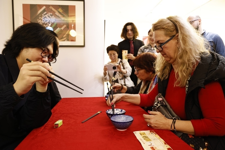 羅馬尼亞觀眾體驗(yàn)用筷子夾花生。中國(guó)文化中心供圖