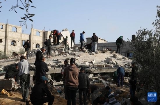  3月3日，在加沙地帶南部城市拉法，人們查看被以軍空襲破壞的建筑。新華社發(fā)（哈立德·奧馬爾攝）