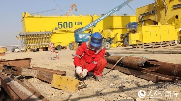 工人正在龍門(mén)吊吊裝現(xiàn)場(chǎng)切割金屬件。人民網(wǎng)記者管克江攝