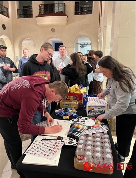 學(xué)生們出發(fā)前紛紛在留言簿留言。人民網(wǎng)記者 鄧圩攝