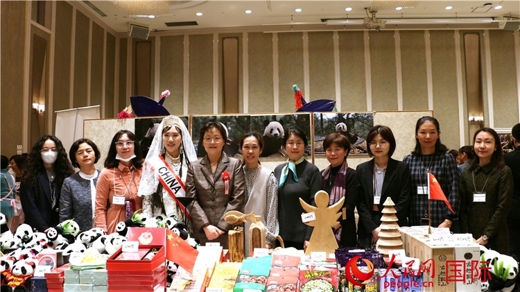 中國駐日本大使吳江浩夫人丁玥（左五）與使館人員在展位前合影留念。人民網 許可攝